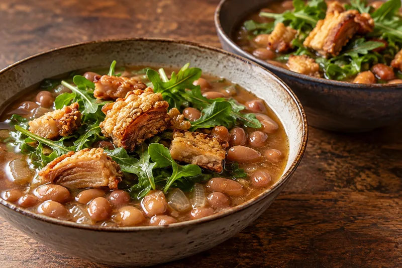 Caldo rápido de frijol con arúgula y chicharrón crujiente